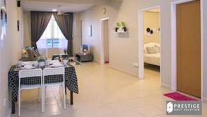 Uma sala moderna com área de jantar, um sofá e uma cama no quarto adjacente.