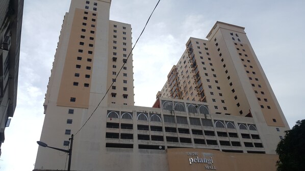 A high-rise building with multiple floors, a prominent entrance, and a sign for 'pelangi mall' at the base. - Prestige Pelangi 1 (Kota Bharu)