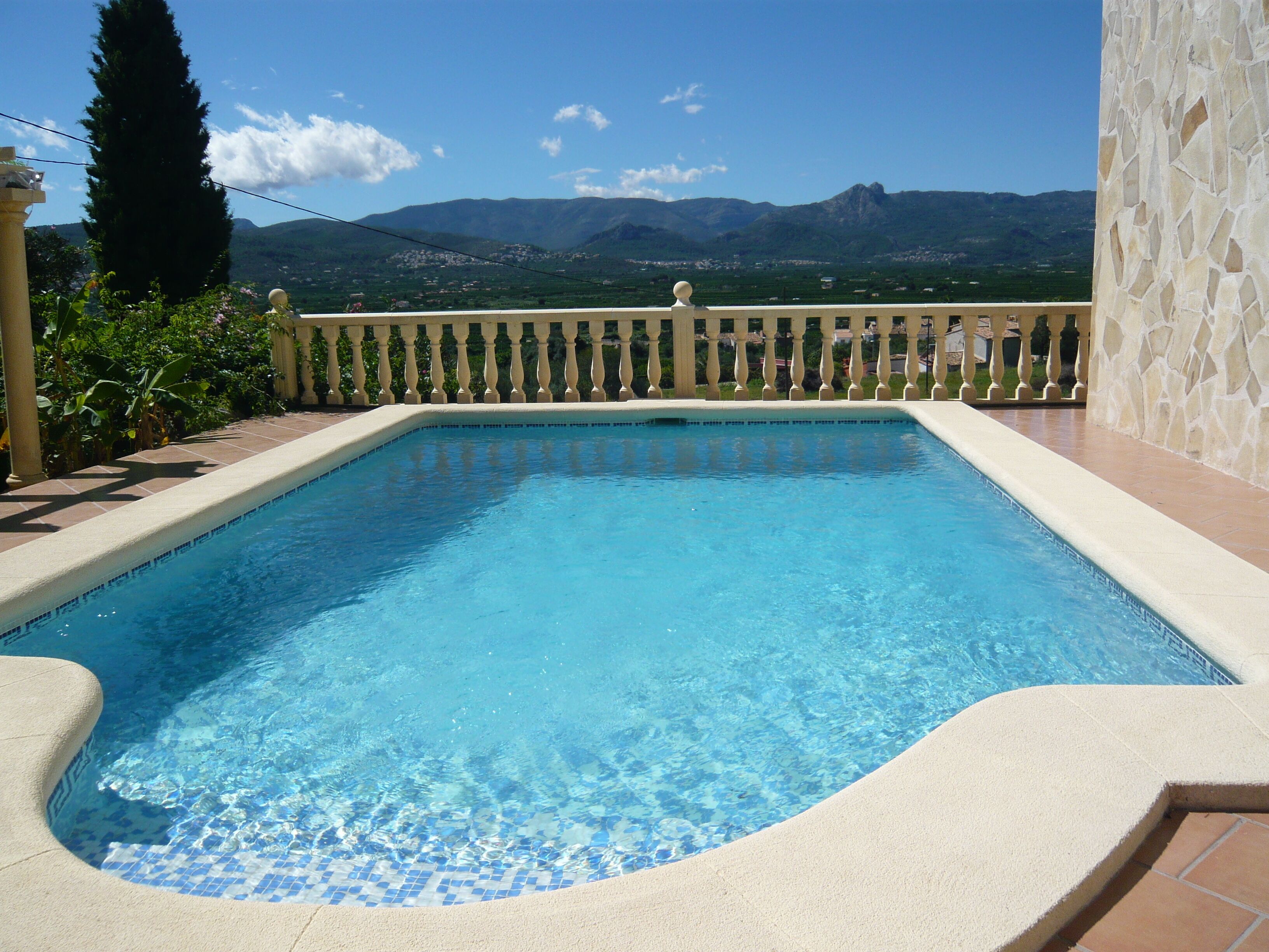 Ein klares, blaues Schwimmbecken mit Blick auf die Berge im Hintergrund.
