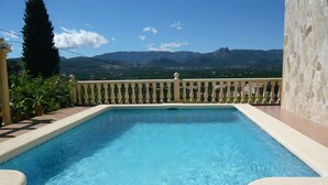 Une piscine d’eau cristalline, avec une vue sur les montagnes en arrière-plan.