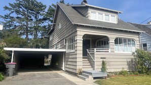 Une maison à deux étages avec un garage, une allée couverte et un porche à l’avant.
