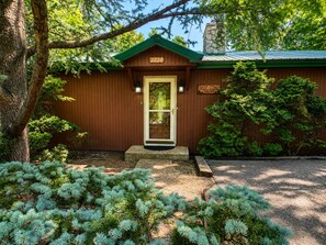A wooden cabin with a green roof, a front door, and a mailbox. - Worth The Climb, Hot tub, bears and Views! (Gatlinburg)