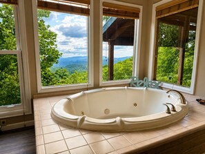 A bathroom with a freestanding bathtub, large windows, and a view of a mountainous landscape. - Worth The Climb, Hot tub, bears and Views! (Gatlinburg)