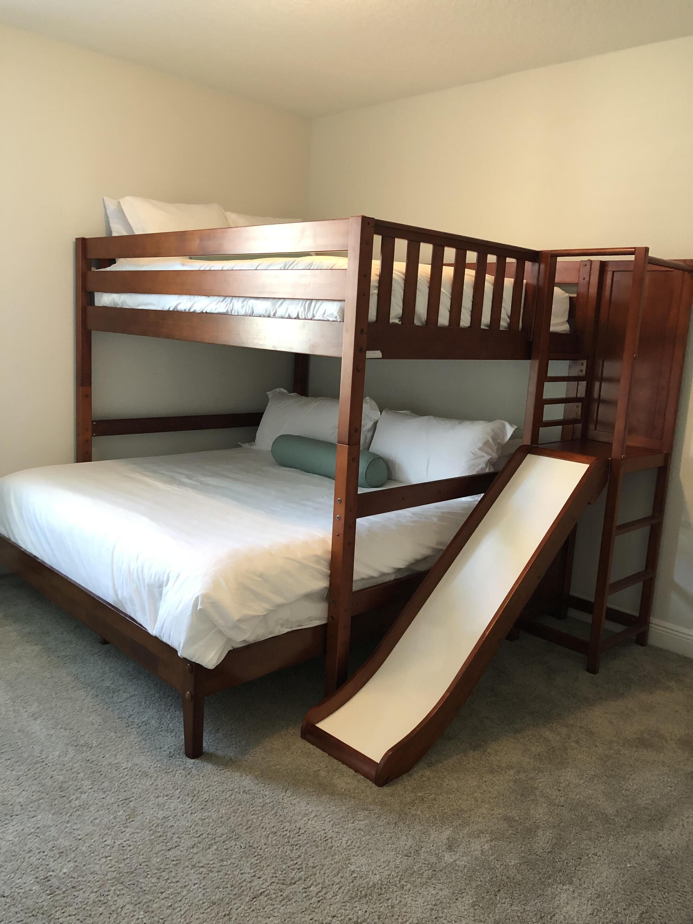 A bunk bed with a slide attached to the side.