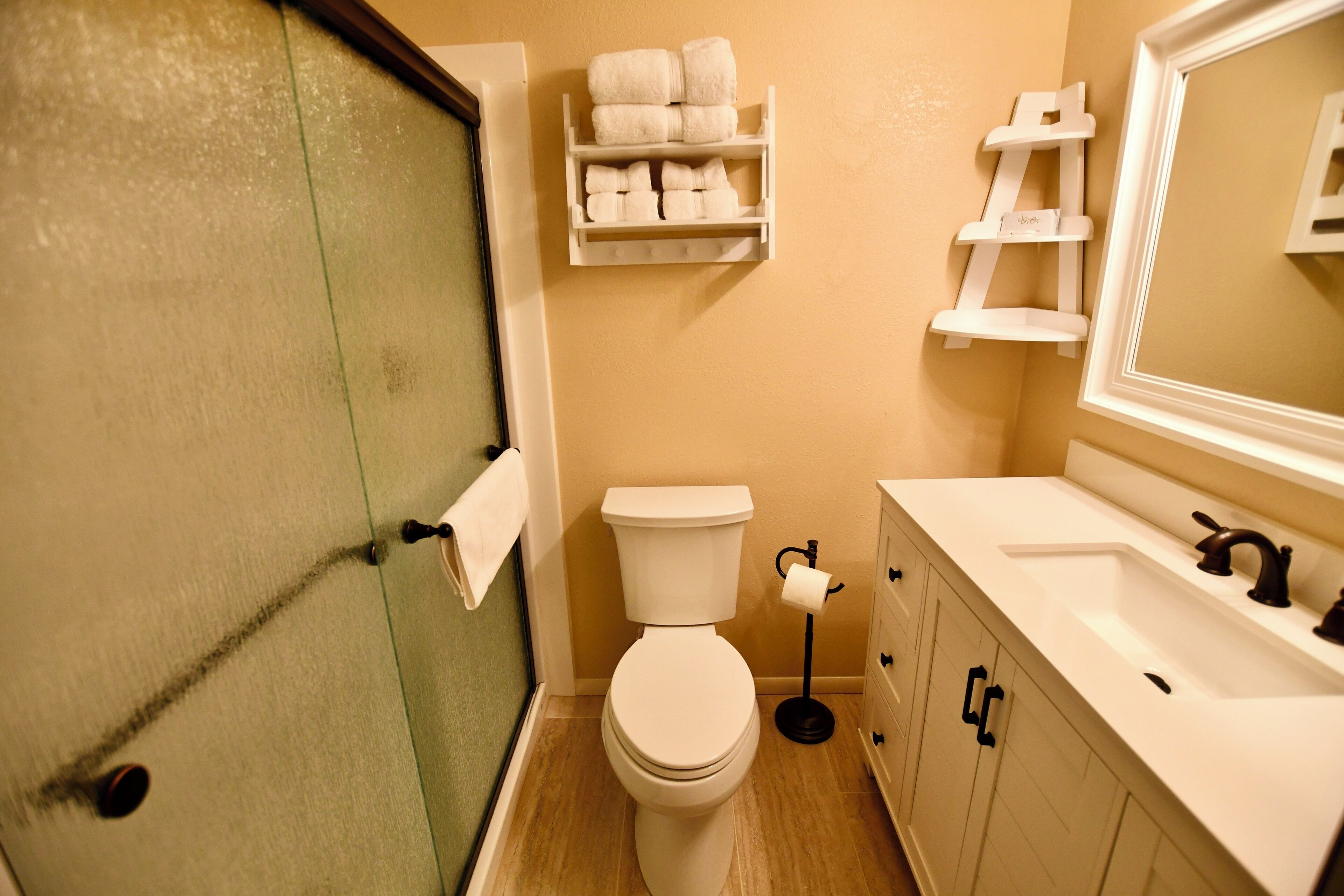 A bathroom with a toilet, sink, and towel rack.