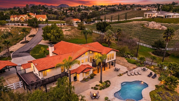 A large house with a swimming pool and outdoor seating area. - Wine Country Estate with Vineyard Views, Pool, Spa, Fire-pit, 4 bedroom Suites (Temecula)