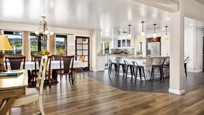 A spacious kitchen with a central island, bar stools, and pendant lighting. - Wine Country Estate with Vineyard Views, Pool, Spa, Fire-pit, 4 bedroom Suites (Temecula)