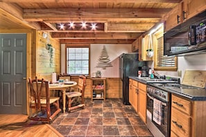 Kitchen area with stove, oven, refrigerator, and dining table.