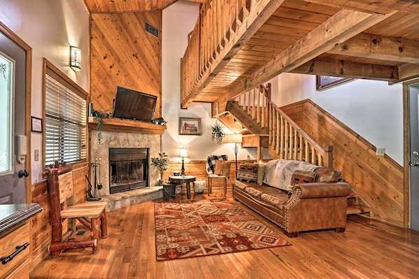 Cozy living area with a fireplace, comfortable seating, and a staircase leading to an upper level.