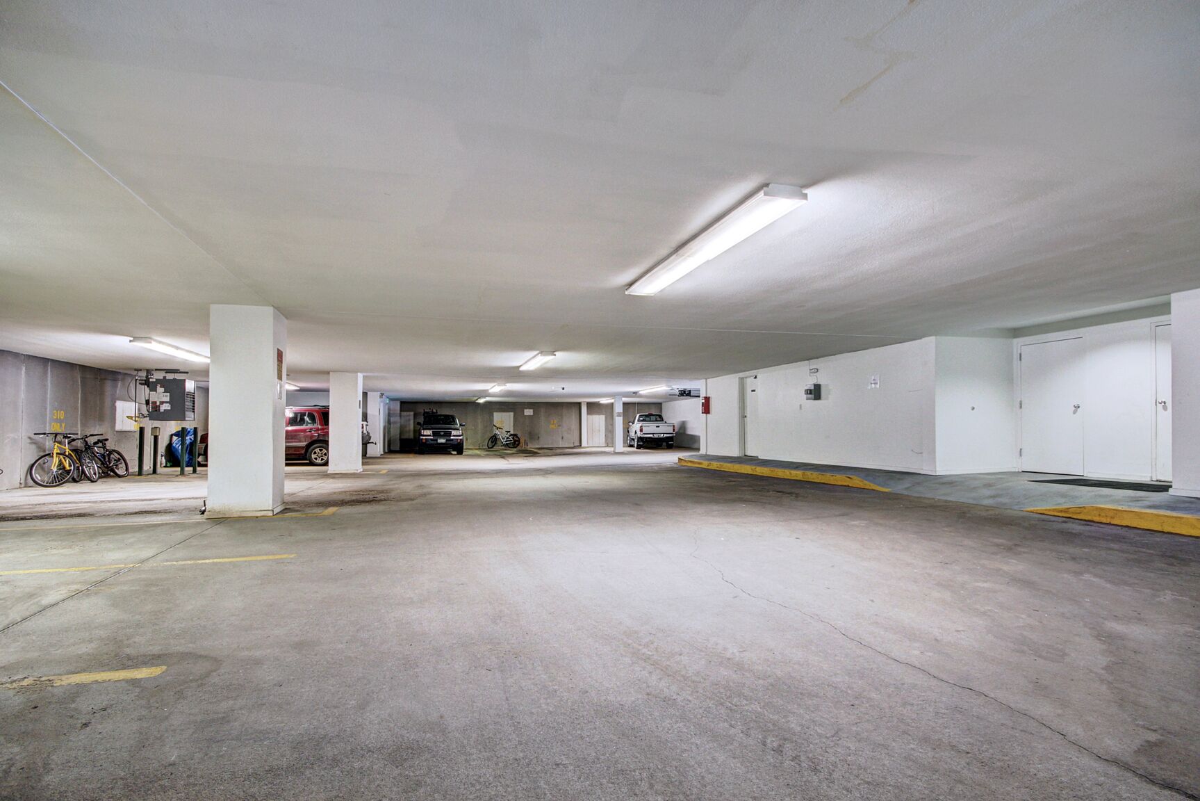 Eine mehrstöckige Tiefgarage mit Betonböden und weißen Wänden.