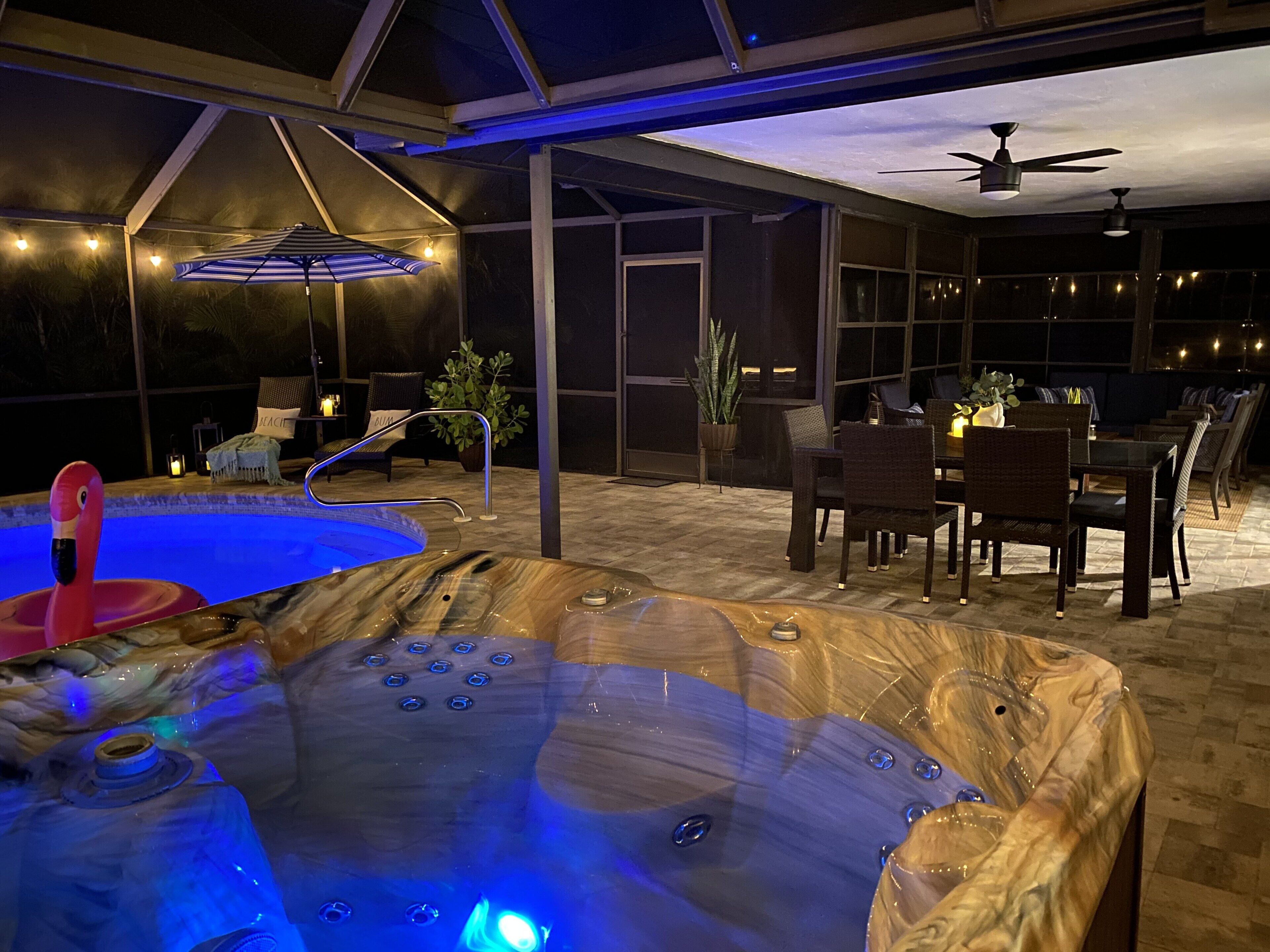 A hot tub with a wooden exterior and a pool with a pink flamingo float.