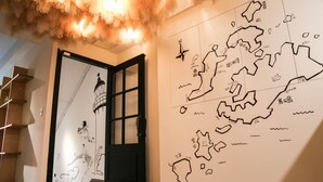 Un pasillo con una puerta negra, un mapa mural y un techo con textura suave.