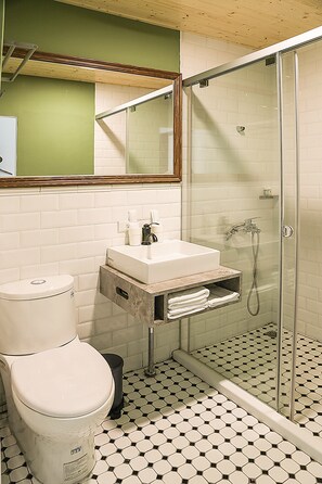 A bathroom with a toilet, sink, and shower.