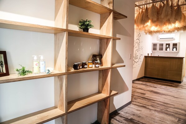A modern interior with wooden shelves, a small plant, and jars of honey. - CandyFloss B&B - Penghu (Magong)