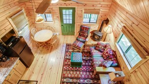 A cozy cabin interior with a dining area, sofa, and a kitchen.