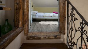 A narrow staircase with a rustic wooden railing leading to a bedroom. The room has a bed with a floral bedspread and a white furry rug. - Stunning private villa with hot tub, private pool, A/C, WIFI, TV, terrace and pets allowed (Loborika)