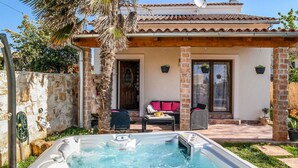 A spa area with a hot tub, outdoor seating, and a stone wall. - Stunning private villa with hot tub, private pool, A/C, WIFI, TV, terrace and pets allowed (Loborika)