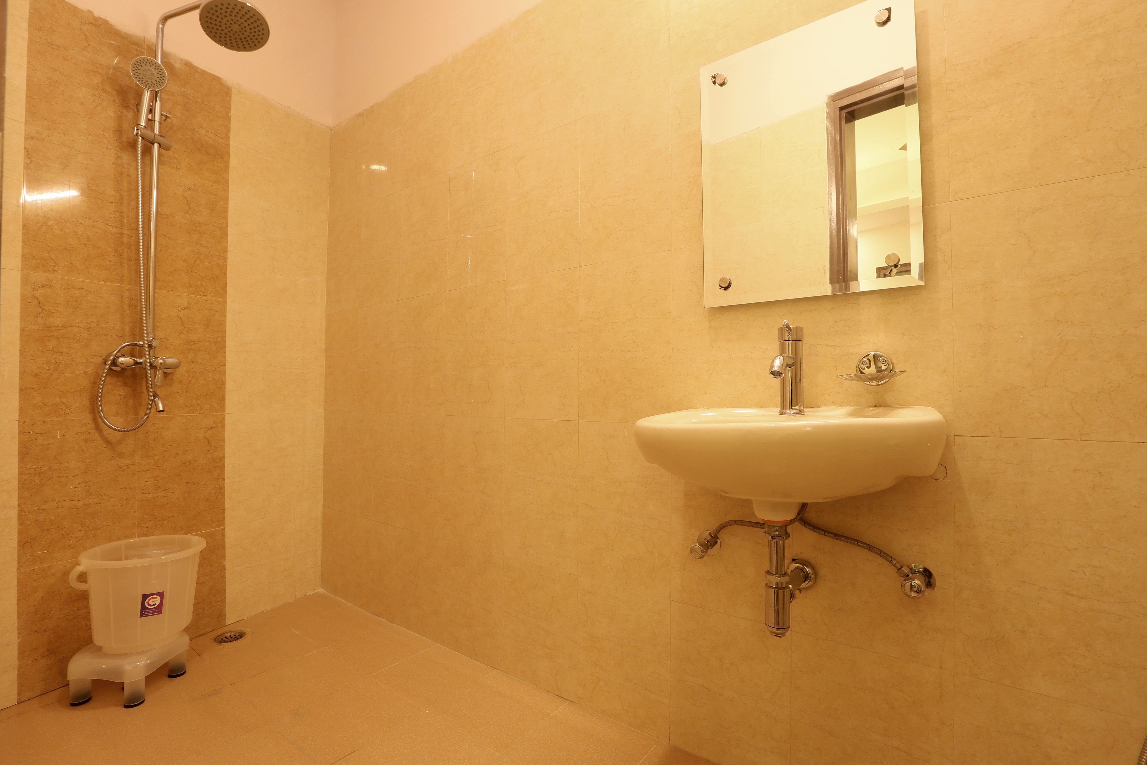 Un baño con ducha, lavamanos y espejo.