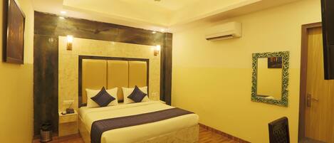 A hotel room with a bed, bedside table, nightstand, and a ceiling fan.
