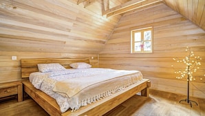 A wooden bedroom with a bed, a bench, a window, and a light fixture. - Wonderful private villa for 4 people with A/C, WIFI, TV and pets allowed (Vrelo Korenicko)