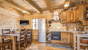 A wooden cabin interior with a dining area, kitchen, and a fireplace. - Wonderful private villa for 4 people with A/C, WIFI, TV and pets allowed (Vrelo Korenicko)