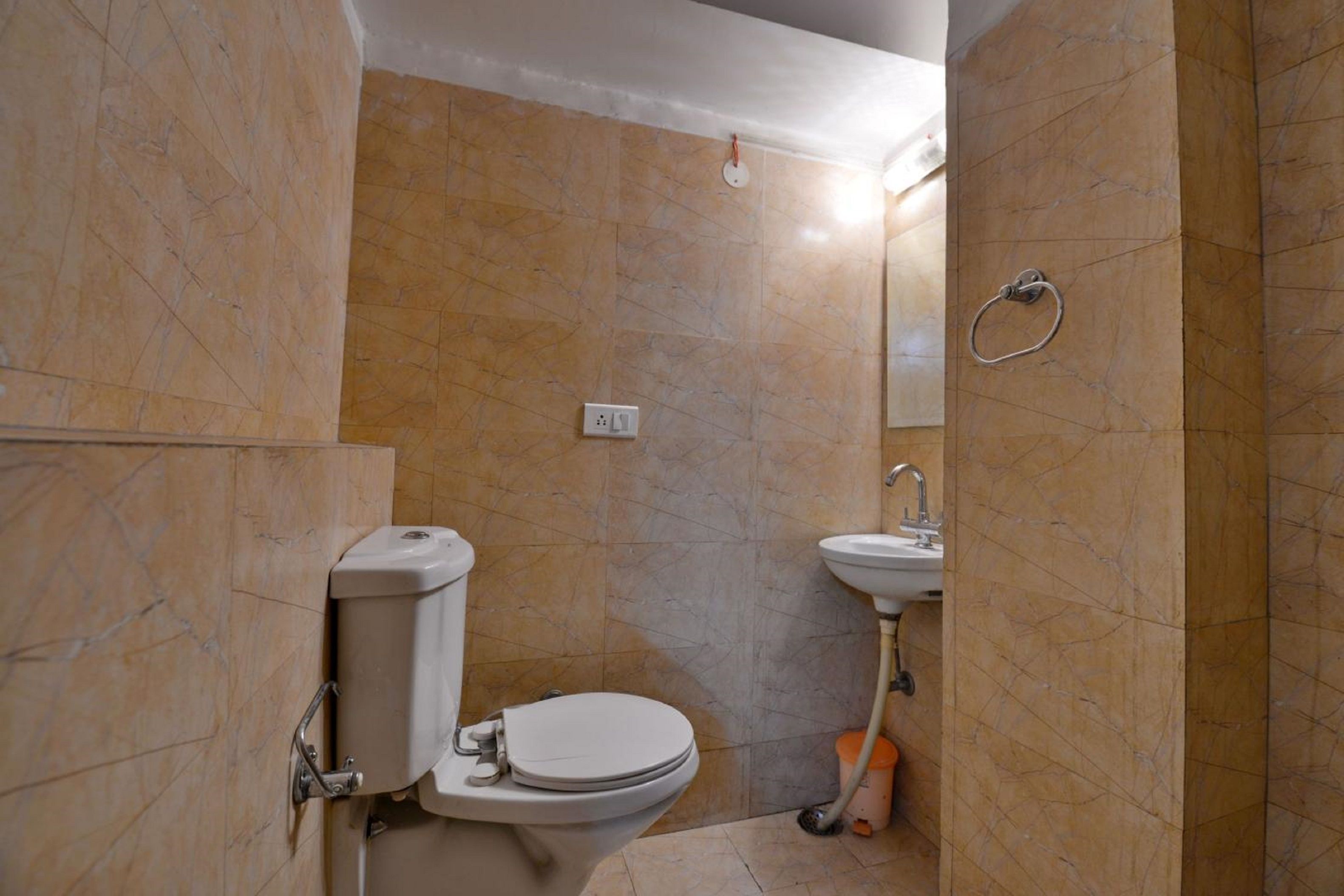 Un baño con inodoro, lavamanos y espejo.
