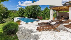 A pool area with a stone patio, lounge chairs, and a covered seating area. - Stunning private villa for 6 people with WIFI, A/C, private pool, TV and terrace (Pazin)