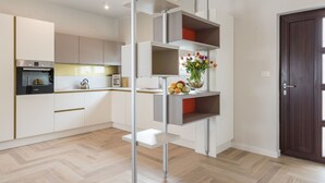 Una cucina moderna con elettrodomestici integrati, un'isola centrale e una porta in legno scuro.