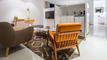 A modern living room with a sofa, a chair, a small table, and a rug.