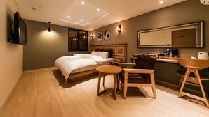 Et moderne hotelværelse med seng, skrivebord og stol.