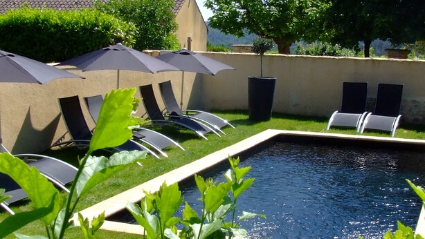 A swimming pool with lounge chairs and umbrellas. - Maison de Marquay (Marquay)