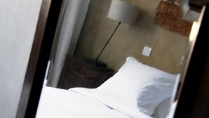A bedroom with a wooden headboard, a bedside table with a lamp, and a bed with white linens. - Maison de Marquay (Marquay)