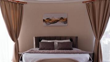 A modern bedroom with a circular bed, beige walls, and a large window with curtains.