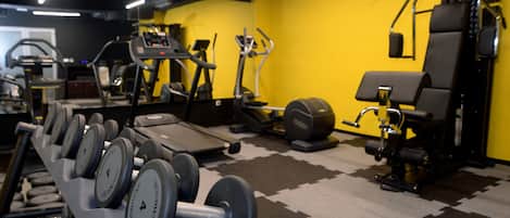 A gym with exercise equipment including treadmills, elliptical machines, and free weights.