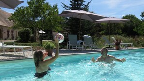 Una piscina con sillas de descanso y sombrillas.