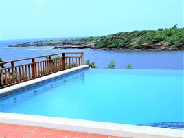 Una piscina al aire libre, sillones reclinables de piscina