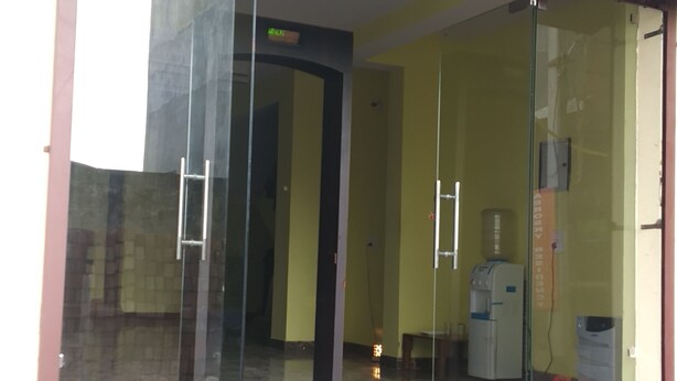 A building entrance with a glass door, a staircase leading up, and a visible hallway inside. - Hotel Jhanvi Palace (New Delhi)