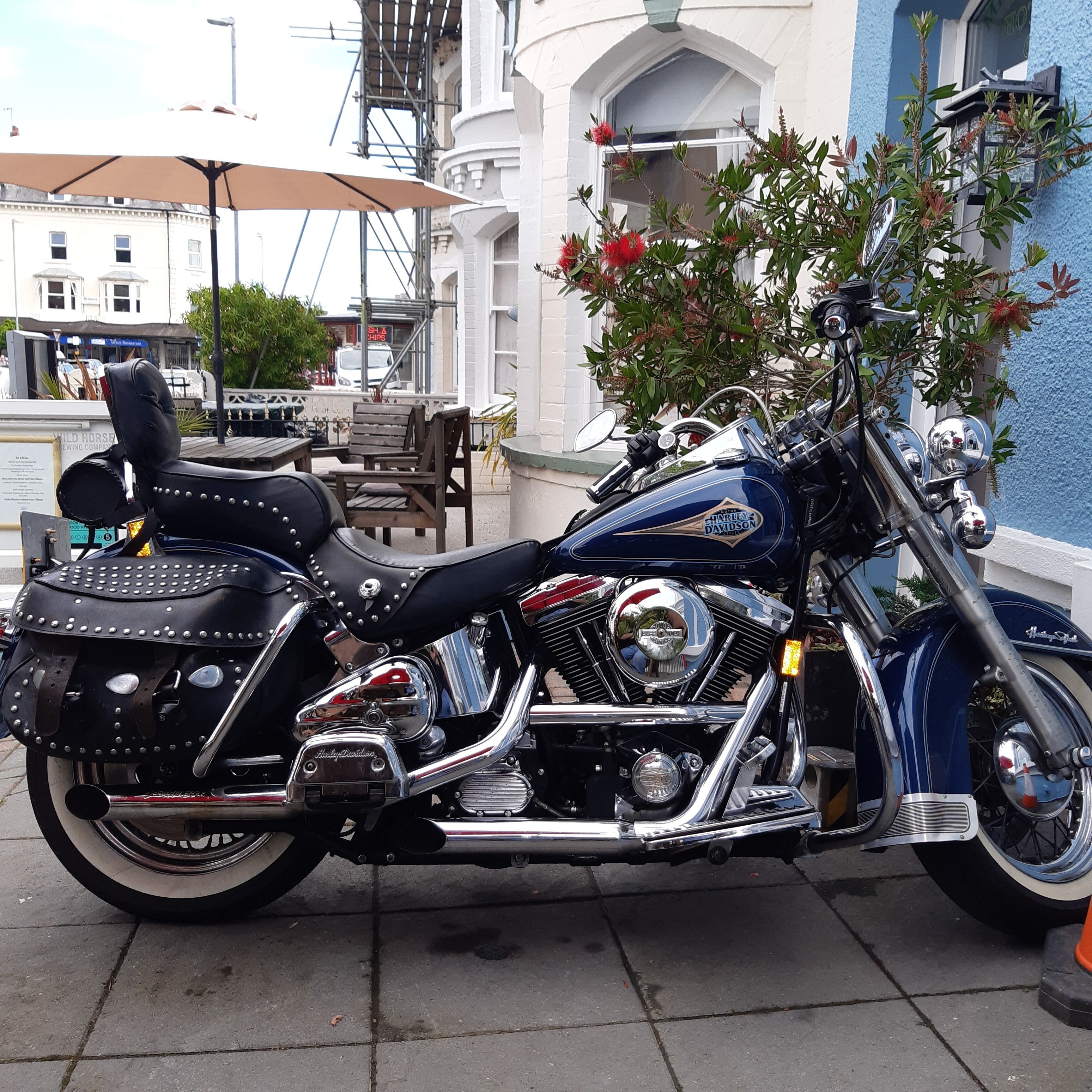 Une moto Harley-Davidson est garée sur un trottoir.
