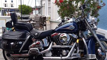 Une moto Harley-Davidson est garée sur un trottoir.