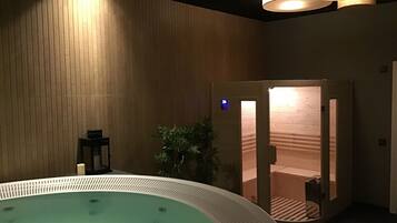 Relax in a serene spa room with a large hot tub and massage area.