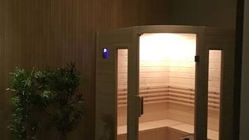 Een sauna met houten wanden, een bankje en een plant in pot.