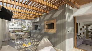 A modern living room with a flat-screen TV, a fireplace, and a balcony with a city view. - Baía I, apartment with luxury design (Funchal)