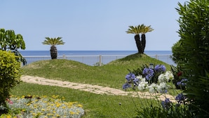 A landscaped garden with a pathway, palm trees, and flowers. - Baía I, apartment with luxury design (Funchal)