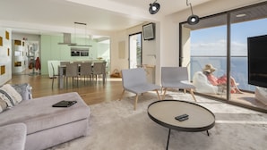 A modern living room with a sofa, chairs, a coffee table, and a balcony with a view. - Baía I, apartment with luxury design (Funchal)