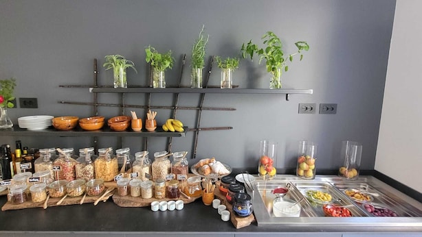 A buffet setup with various food items and condiments. - Locanda Restel de Fer (Riva del Garda)