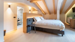 A bedroom with a bed, a small table, and a wardrobe. - Locanda Restel de Fer (Riva del Garda)