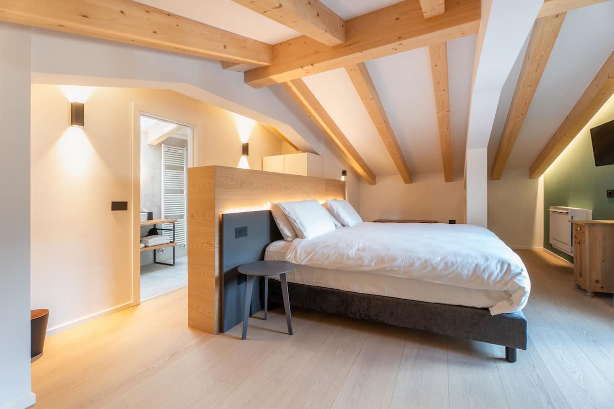 A bedroom with a bed, a small table, and a wardrobe.