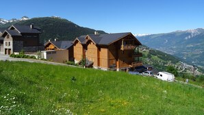 A mountain lodge with wooden cabins, a ski lift, and a view of snow-capped mountains. - Charming 4-room apartment, sleeps 8, near slopes, parking, WIFI (Peisey-Vallandry)