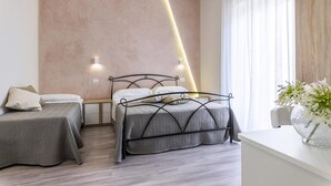 Un dormitorio moderno con una cama grande, dos mesitas de noche y una lámpara fijada a la pared.
