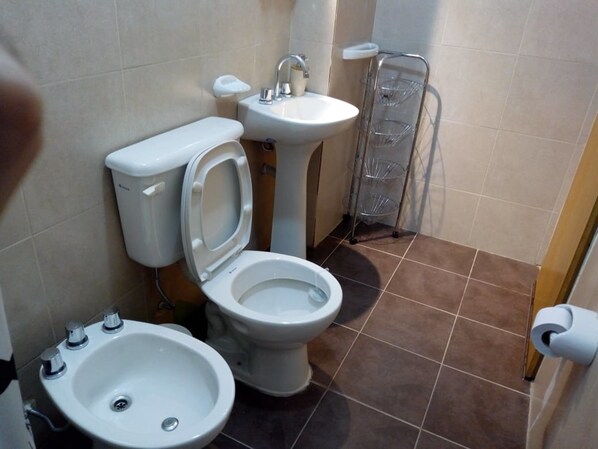A bathroom with a toilet, bidet, and sink.
